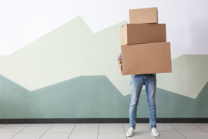 Man with moving boxes near color wall